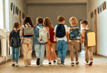 Missing Kids Crisis — Shocking Gaps Exposed A group of children walking together in a school hallway, each carrying a backpack