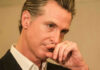 Whistleblowers Rock California’s First Family Close-up of a man in a suit with a thoughtful expression, hand on chin