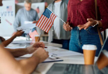 Noncitizen Voting Shock Hits New Jersey People participating in a voting event with American flags and paperwork