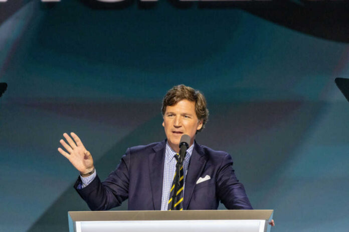 A man in a suit speaking at a podium with a microphone