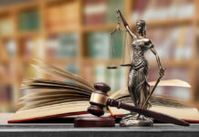 Appeals Bombshell Freezes Alabama Execution A gavel and a statue of Lady Justice beside an open law book
