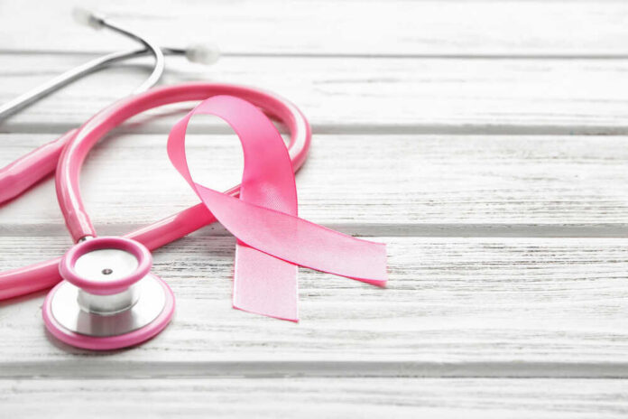 Pink,Ribbon,And,Stethoscope,On,Wooden,Background,,Closeup.,Breast,Cancer A pink ribbon next to a stethoscope on a wooden surface