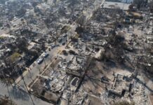 Putin’s ‘Victory’ Sparks Instant Rebuttal Aerial view of a neighborhood devastated by wildfire, showing burned structures and debris