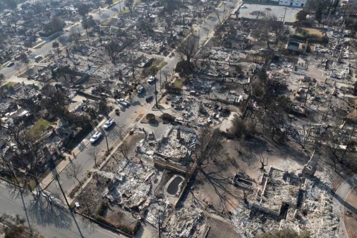 A,Drone,Captures,Structures,Damaged,By,The,Eaton,Fire,In Aerial view of a neighborhood devastated by wildfire, showing burned structures and debris