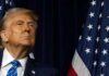 Trump’s Diesel Do-Over Sparks Fury A political figure looking upward beside an American flag
