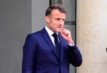 Stolen Millions Circle Back to Damascus Emmanuel Macron in a suit, standing outdoors with a thoughtful expression