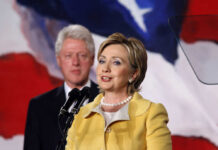 Netflix Blast: Clinton Torches Electoral College Hillary Clinton speaking at a podium with Bill Clinton in the background