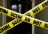 Foreign Plot Hinted After Drone Factory Blaze Yellow crime scene tape crossing a doorway