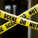 Foreign Plot Hinted After Drone Factory Blaze Yellow crime scene tape crossing a doorway