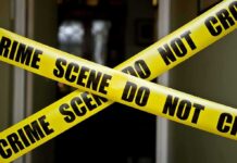 Foreign Plot Hinted After Drone Factory Blaze Yellow crime scene tape crossing a doorway