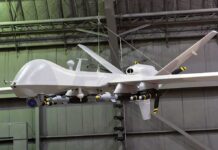 military drone with missiles suspended in a hangar