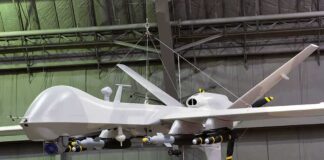 military drone with missiles suspended in a hangar