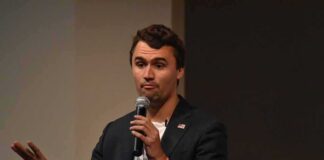 man speaking into a microphone on stage