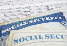 2032 Shock: Automatic Benefit Cuts Social Security cards on top of a tax form