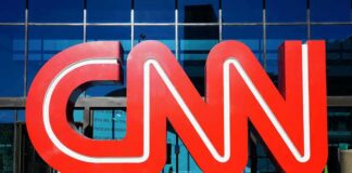 CNN red logo sculpture outside a glass-fronted building