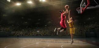 Two basketball players contest a layup under the hoop