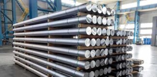 Stacked metal rods on pallets in an industrial warehouse