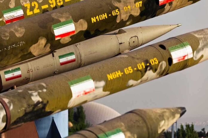 shutterstock_1517938886 Row of military missiles with camouflage and national flags