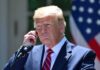 Trump Hands Out Ultra-Rare Space Honor man in suit at podium adjusting earpiece