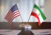 Compensation Gambit Rattles Iran Talks United States and Iran desk flags on a stand