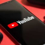 FTC Targets YouTube: Rulebook on Trial smartphone displaying YouTube logo on red background