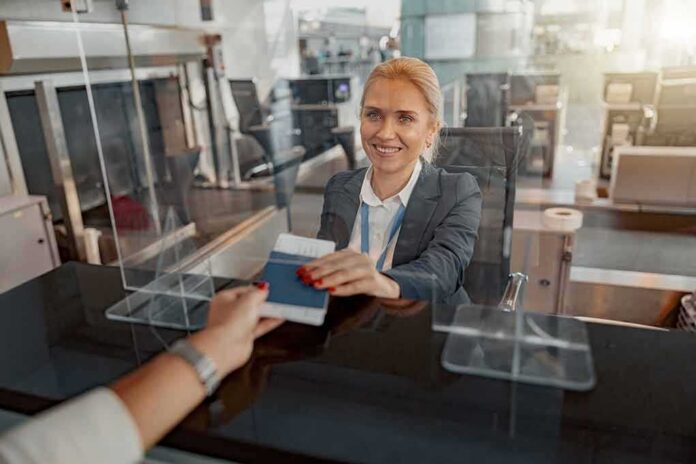 shutterstock_2186094269-1 airport check-in agent handing back a passport