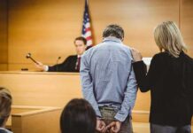 Aid Giant Exposed—Hamas Ties Alleged Defendant in handcuffs stands before a judge in a courtroom