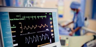 Patient monitor displaying vital signs in a hospital room