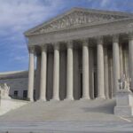 The Supreme Court building featuring large columns and statues