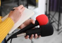 SHOCKING Trial Upends VA Playbook Journalist holding two microphones while writing in a notebook
