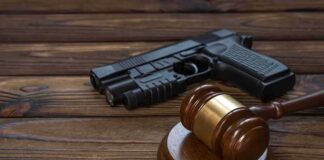 Gavel and handgun on wooden table