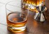 Trump Axes Whisky Tariffs After Royal Visit Whiskey in a rocks glass on a wooden table