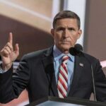 Michael Flynn speaking at a podium with a raised finger gesture