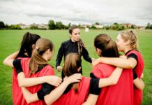 Supreme Court Stakes Ignite Hometown Softball Coach talks to youth team in a huddle on a field