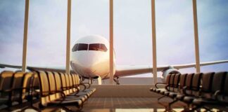 Airplane seen through terminal windows with empty gate seating