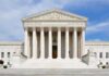 Voter Purge Fight Hits Supreme Court Front view of the Supreme Court building with large columns and steps under a blue sky