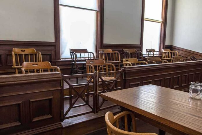 shutterstock_1403556146 Empty jury box in a courtroom with wooden chairs