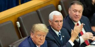 three men in suits seated at a conference table