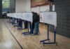 Immigrant Aid Rule Ignites Court Brawl Voters at polling booths in a gymnasium