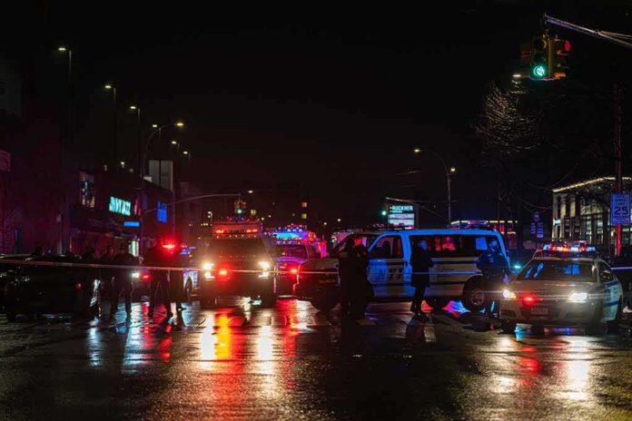shutterstock_1903071622-1 Nighttime police scene with flashing lights on a wet city street