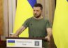 Ireland Pit Stop: Spy Boss Meets Zelensky Man at a podium with Ukrainian flags