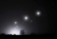 Pentagon Drops More UAP Bombshells Night sky over a silhouetted landscape with glowing orbs of light