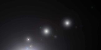 Night sky over a silhouetted landscape with glowing orbs of light
