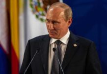 Putin’s Stark Warning Rattles Europe Vladimir Putin at a podium during a formal event