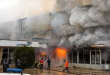 firefighters respond to large building fire with heavy smoke