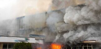 firefighters respond to large building fire with heavy smoke