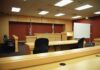 NFL Wild Card: Murder Charge Vanishes Interior view of an empty courtroom with wooden furniture and American flags