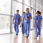 Kia Nurse walking with fellow medical staff in hospital corridor