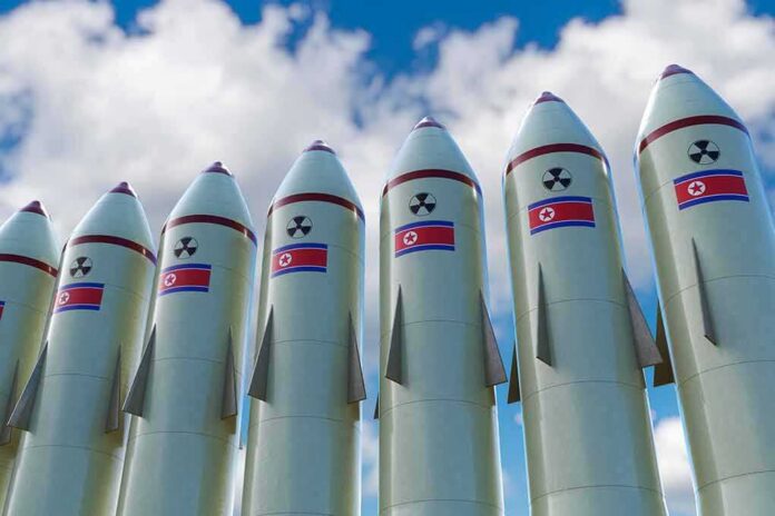 Row of missiles with flags and radiation symbols against a cloudy sky