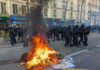 Looting Chaos Triggers Paris Clampdown Fire burning on the street amid police presence.